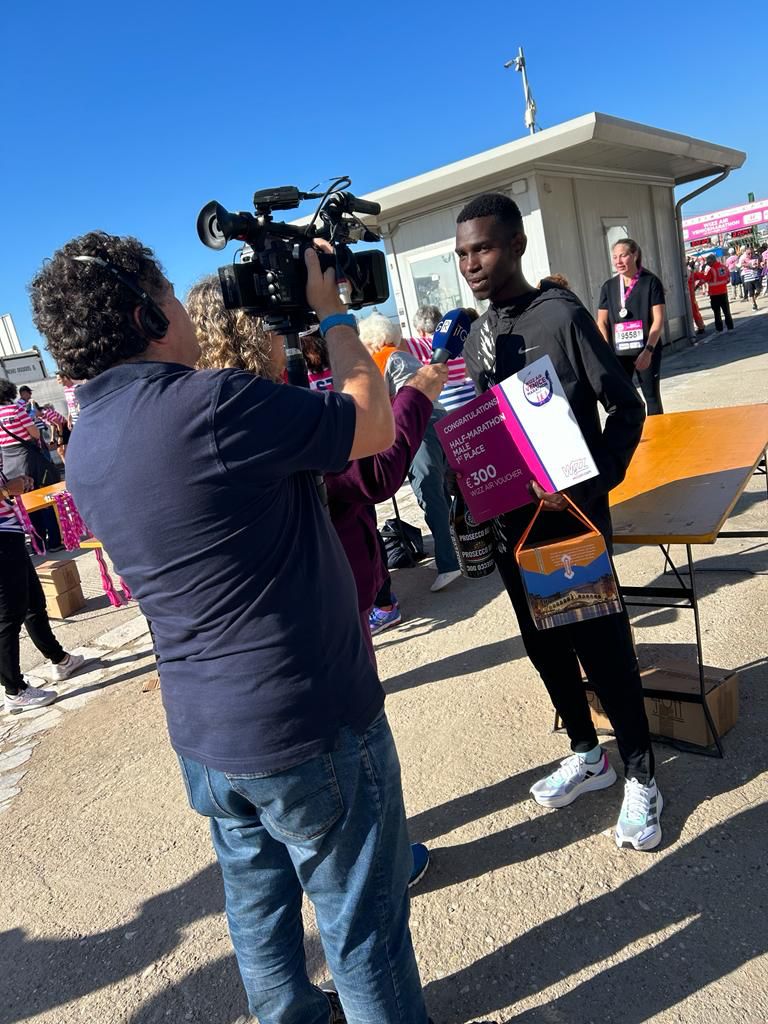 Erick dando entrevista com o voucher da corrida em Veneza.
