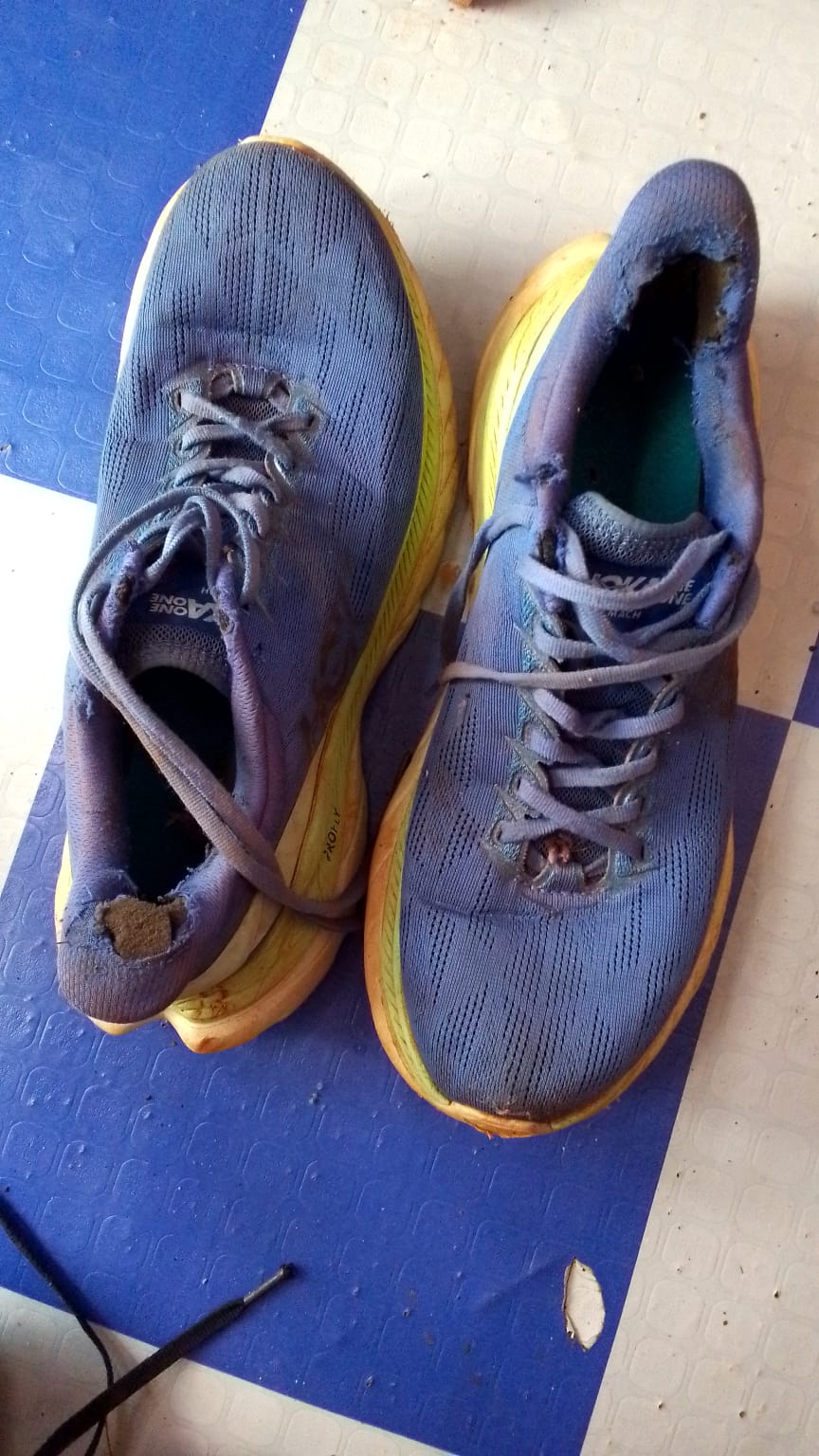 Tênis de treino velho e desgastado de Erick, mostrando a necessidade de equipamento novo.